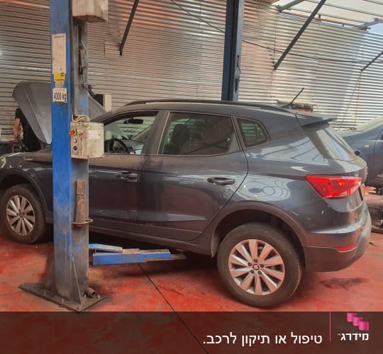 רכב במוסך על רצפת בטון אדומה